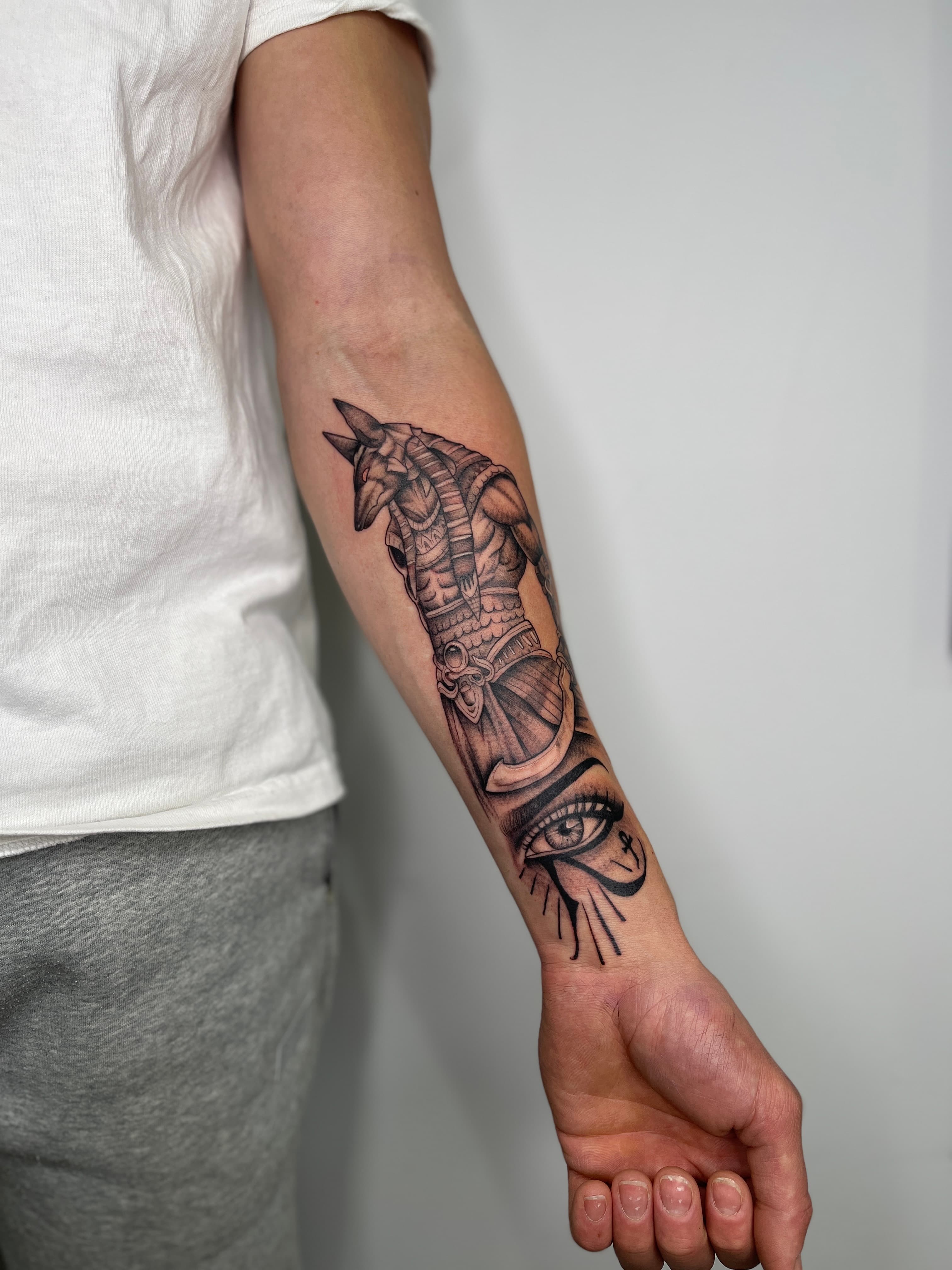 Black-and-grey anubis on male inner forearm by AinsleyXTattoos