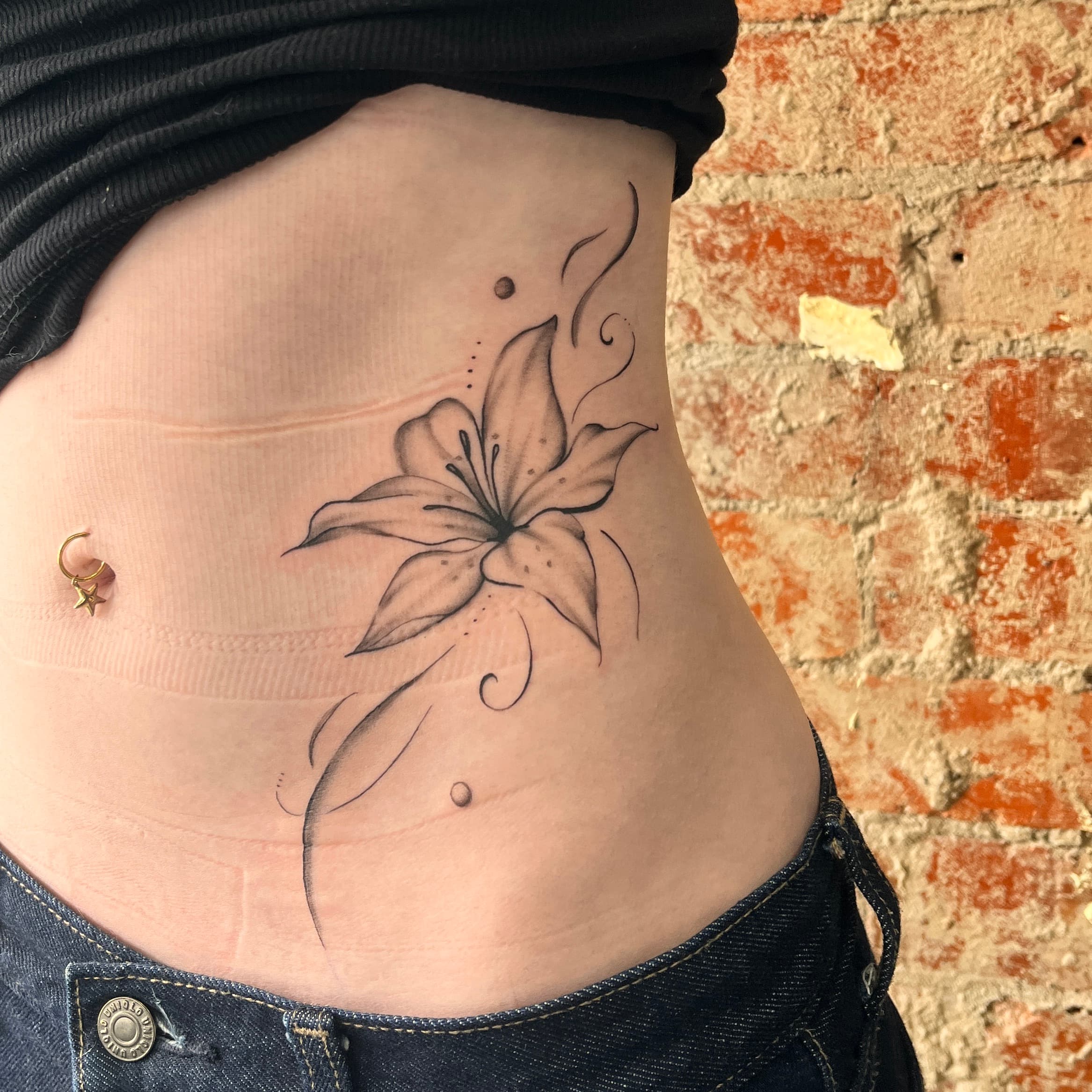 Fineline Black-and-grey framing female stomach and hip by AinsleyXTattoos